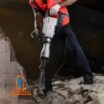 کاربر با چکش تخریب 2814 یک دیوار بتنی قطور را خرد میکند