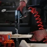 کاربر با دریل RA-1402 در حال باز کردن پیچهای موتور خودرو